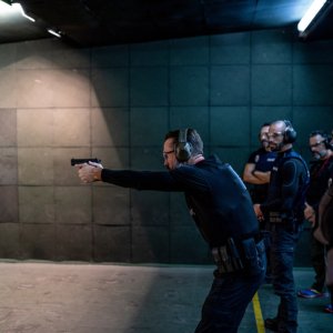 Police training in shooting gallery with short weapon.