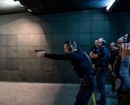 Police training in shooting gallery with short weapon.