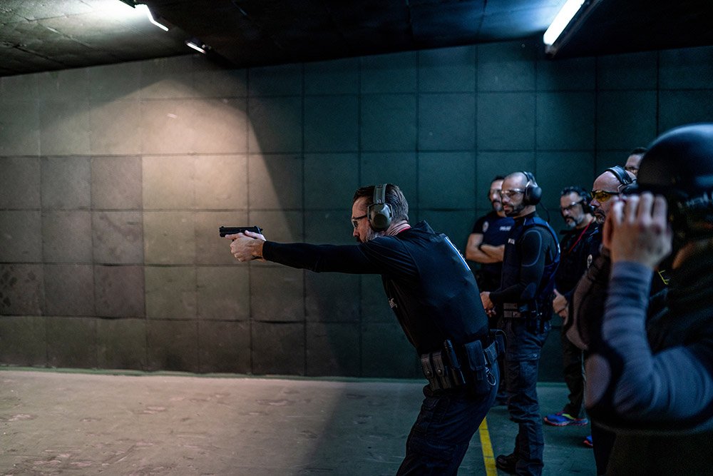 Police training in shooting gallery with short weapon.